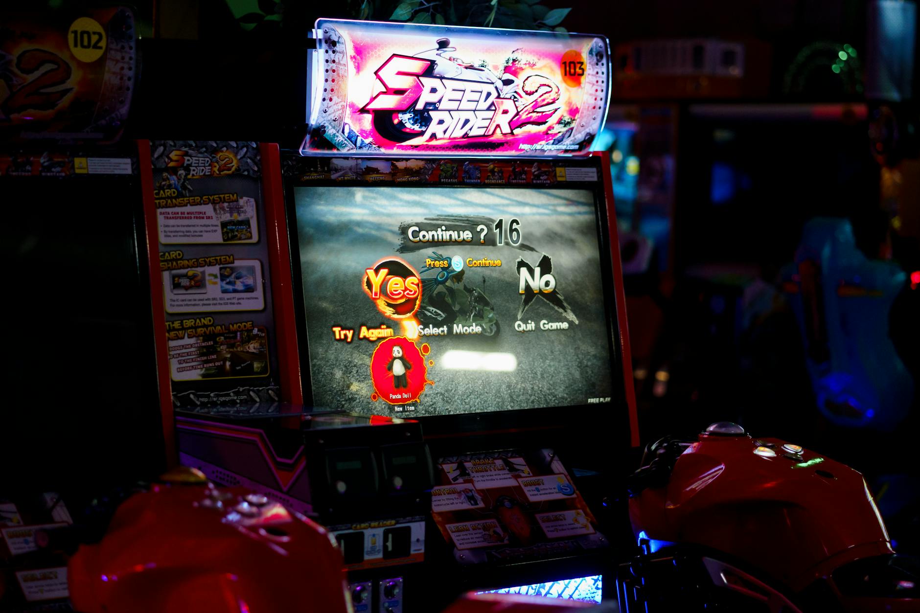 Zbliżenie na ekran automatu arcade z grą wyścigową w salonie gier